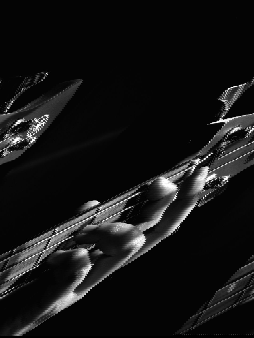 person playing guitar grayscale photo